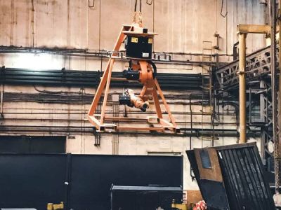An industrial robot lifting a metal component in a production hall