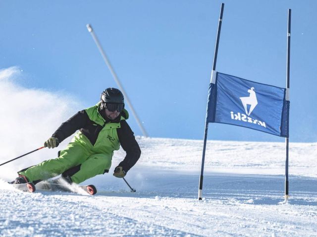 Skisch&uuml;lerinnen und Skisch&uuml;ler auf einer Piste im Skigebiet KitzSki bei Mittersill